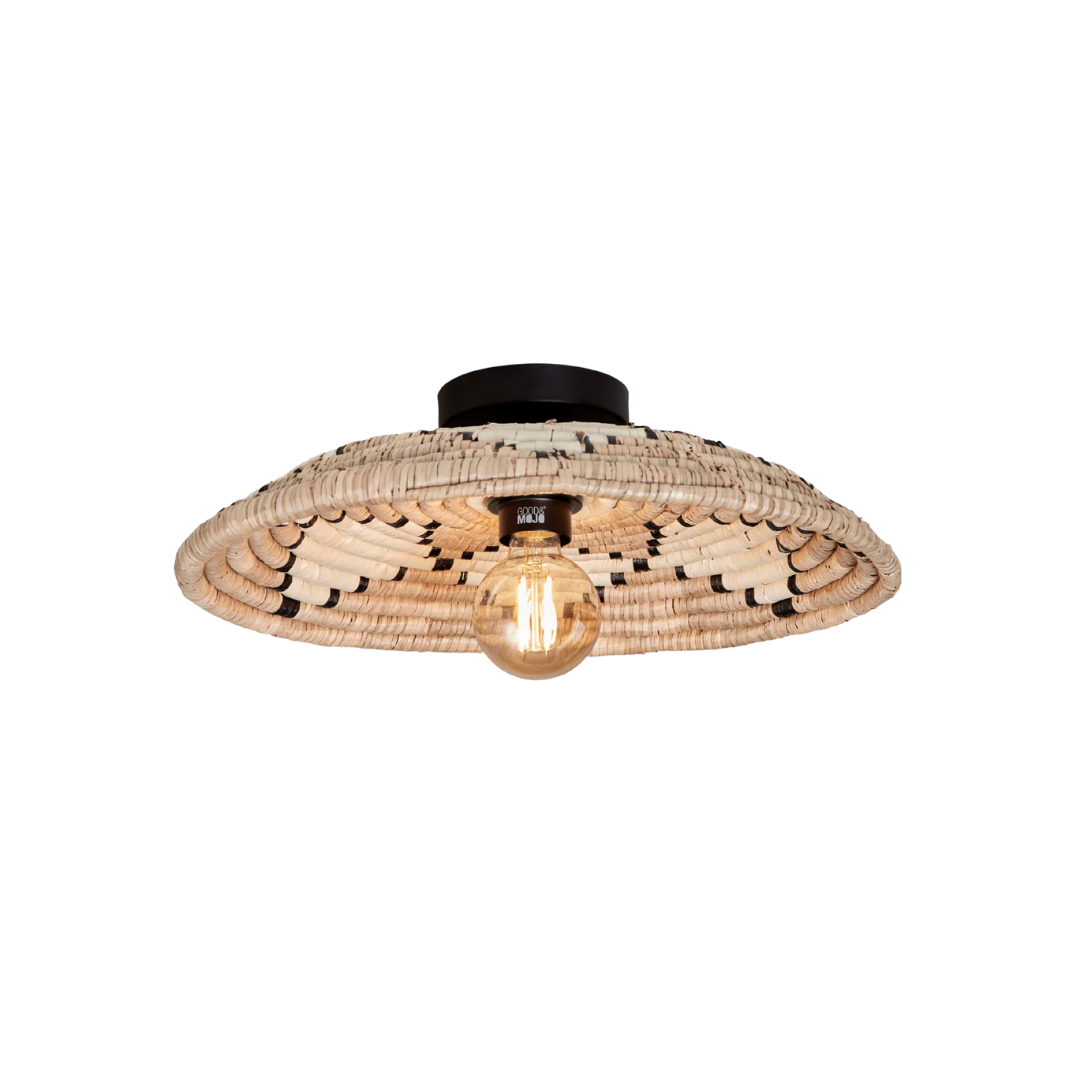 Ein Bild aus dem Taiga Store von taiga.green. Die Deckenlampe Andros ist eine Deckenleuchte mit einem breiten, geflochtenen Rattanschirm und einer freiliegenden Glühbirne, montiert auf einem schwarzen Sockel. Durchmesser: 45 cm, Höhe: 8 cm. Jetzt bestellen im Eco Shop von www.taiga.green. Hier nachhaltig einkaufen mit dem Taiga Eco Rating