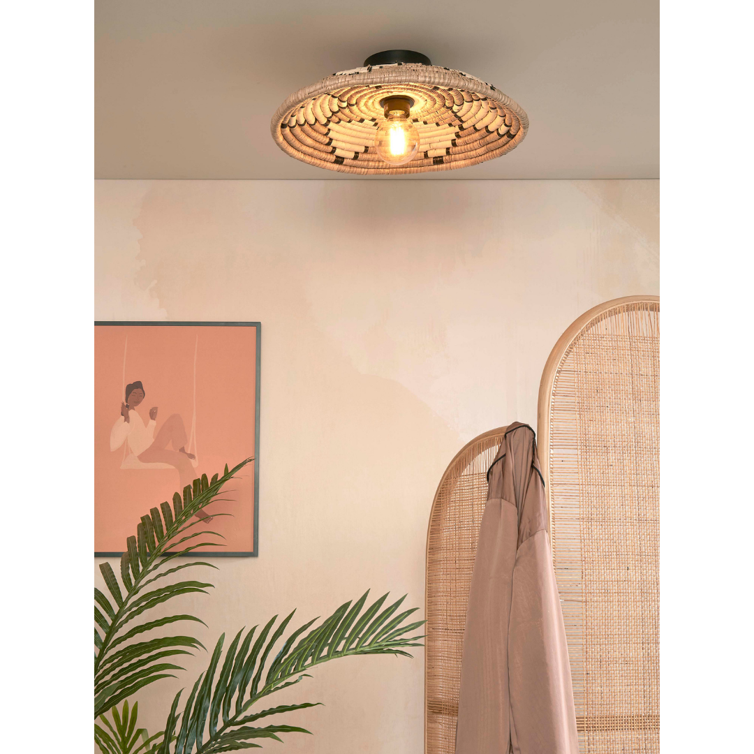 Ein Bild aus dem Taiga Store von taiga.green. Ein stilvolles Zimmer mit der Deckenlampe Andros Diam.45x8cm, einem rosa Wandbild mit einer Person, einer grünen Pflanze, einem beigen Paravent und einem beigen Mantel, der vor einer hellen Wand hängt. Jetzt bestellen im Eco Shop von www.taiga.green. Hier nachhaltig einkaufen mit dem Taiga Eco Rating
