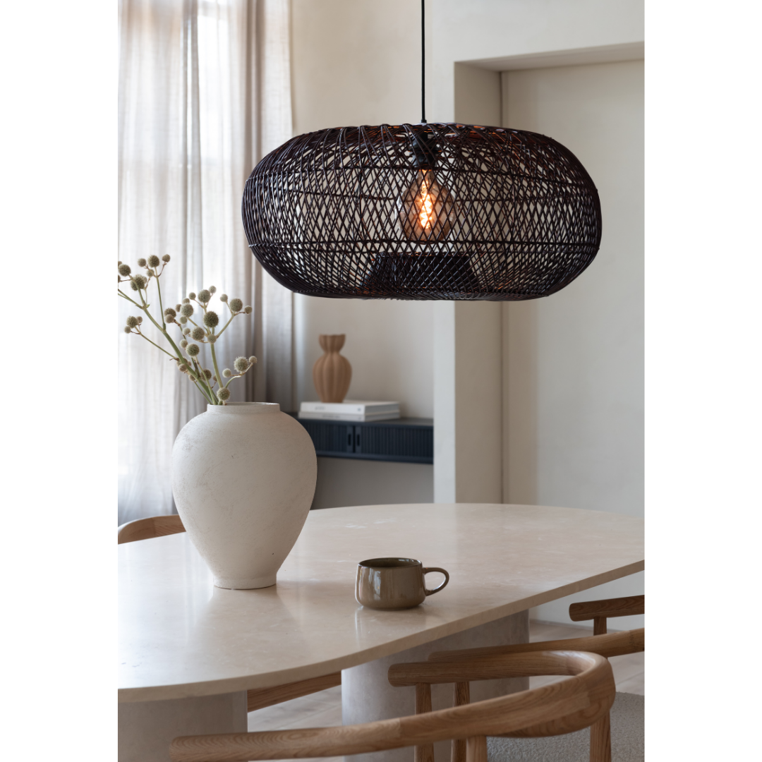 Ein Bild aus dem Taiga Store von taiga.green. Die Hängelampe Arizona rattan/Schirm ø70xh.34cm L hängt über einem hellen Esstisch mit einer weißen Vase aus Zweigen, grünem Becher und zwei Holzstühlen, beleuchtet von weichem Tageslicht durch transparente Vorhänge. Jetzt bestellen im Eco Shop von www.taiga.green. Hier nachhaltig einkaufen mit dem Taiga Eco Rating
