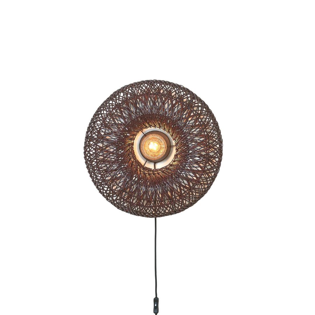 Ein Bild aus dem Taiga Store von taiga.green. Die Wandlampe Arizona hat einen runden Rattanschirm (ø50x23cm) mit einer freiliegenden Glühbirne in der Mitte, die ein warmes Licht abgibt. Das kreisförmige Flechtmuster und das sichtbare schwarze Kabel mit Schalter verleihen jeder Wand einen besonderen Charme. Jetzt bestellen im Eco Shop von www.taiga.green. Hier nachhaltig einkaufen mit dem Taiga Eco Rating