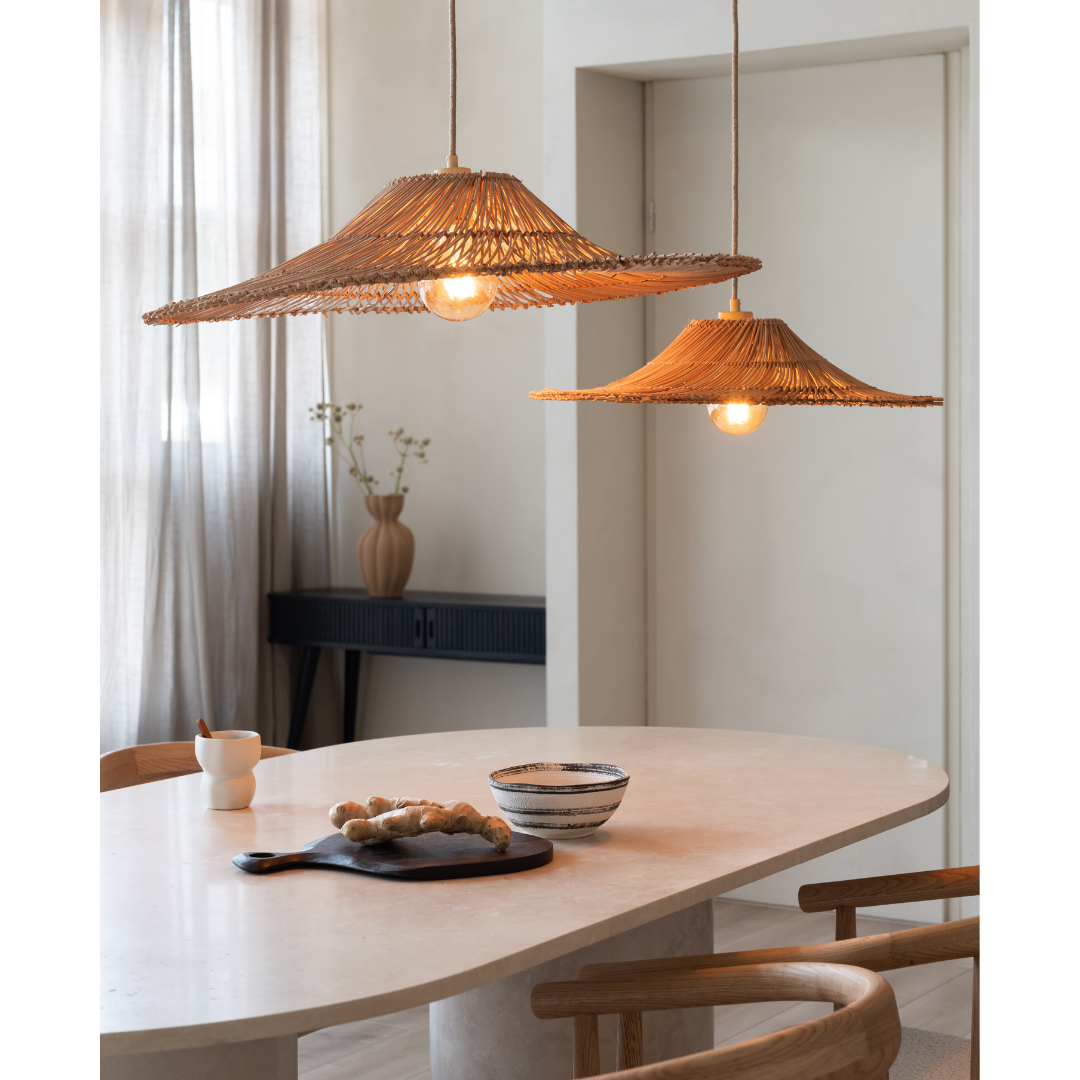 Ein Bild aus dem Taiga Store von taiga.green. Ein moderner Essbereich mit einem hellen Steintisch, Holzstühlen, zwei geflochtenen Rattan-Pendelleuchten, einer Vase mit Blumen, einer Tasse, einer Schale und einem Holztablett mit Gebäck. Sanftes natürliches Licht fällt durch die durchsichtigen Vorhänge. Jetzt bestellen im Eco Shop von www.taiga.green. Hier nachhaltig einkaufen mit dem Taiga Eco Rating
