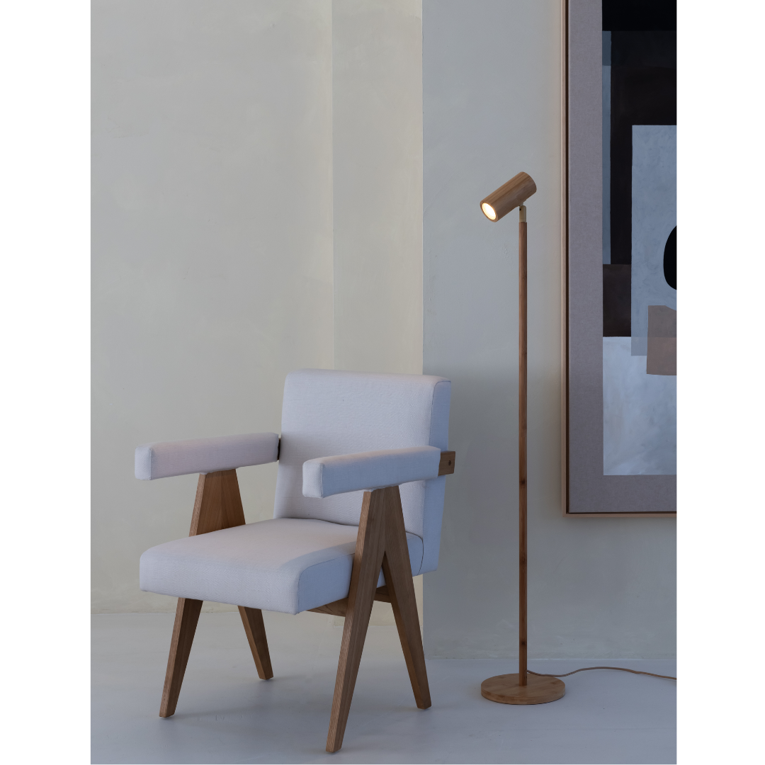 Ein Bild aus dem Taiga Store von taiga.green. Ein moderner Sessel aus hellem Holz mit weißen Kissen steht neben einer hohen Stehlampe aus Holz. Ein abstraktes Kunstwerk in neutralen Tönen hängt an einer beigen Wand in einem minimalistischen Raum. Jetzt bestellen im Eco Shop von www.taiga.green. Hier nachhaltig einkaufen mit dem Taiga Eco Rating