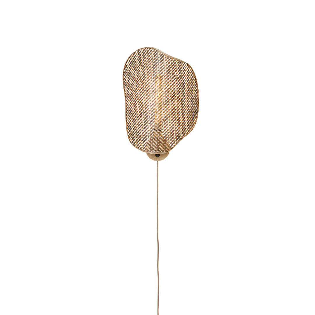 Ein Bild aus dem Taiga Store von taiga.green. Eine moderne Wandleuchte mit einem geflochtenen, unregelmäßig geformten Rattanschirm, montiert auf einem runden Sockel mit einer sichtbaren, herabhängenden Kordel, vor einem schlichten schwarzen Hintergrund. Jetzt bestellen im Eco Shop von www.taiga.green. Hier nachhaltig einkaufen mit dem Taiga Eco Rating