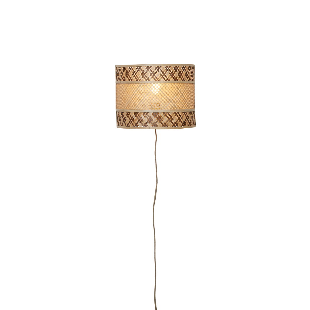 Ein Bild aus dem Taiga Store von taiga.green. Ein geflochtener Rattan-Lampenschirm in zylindrischer Form mit dekorativen braunen Mustern hängt mit einer sichtbaren Schnur von der Decke und leuchtet sanft, wenn das Licht eingeschaltet ist. Jetzt bestellen im Eco Shop von www.taiga.green. Hier nachhaltig einkaufen mit dem Taiga Eco Rating