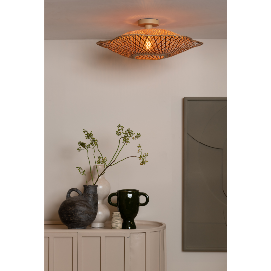 Ein Bild aus dem Taiga Store von taiga.green. Ein modernes Zimmer mit der Deckenlampe Madura Bambus/Schirm ø60x15cm M, einem beigefarbenen, geschwungenen Schrank, drei dekorativen Vasen (eine mit Grünzeug) und geometrischer Wandkunst an einer neutralen Wand. Jetzt bestellen im Eco Shop von www.taiga.green. Hier nachhaltig einkaufen mit dem Taiga Eco Rating