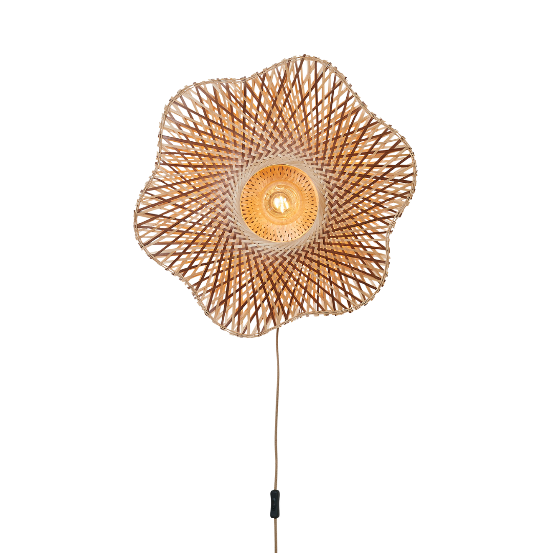 Ein Bild aus dem Taiga Store von taiga.green. Die Wandlampe Madura Bambus ø60x15cm M hat einen blumenförmigen Schirm aus geflochtenem Rattan mit einer sichtbaren runden Glühbirne in der Mitte, die an einer Schnur mit integriertem Schalter befestigt ist. Jetzt bestellen im Eco Shop von www.taiga.green. Hier nachhaltig einkaufen mit dem Taiga Eco Rating