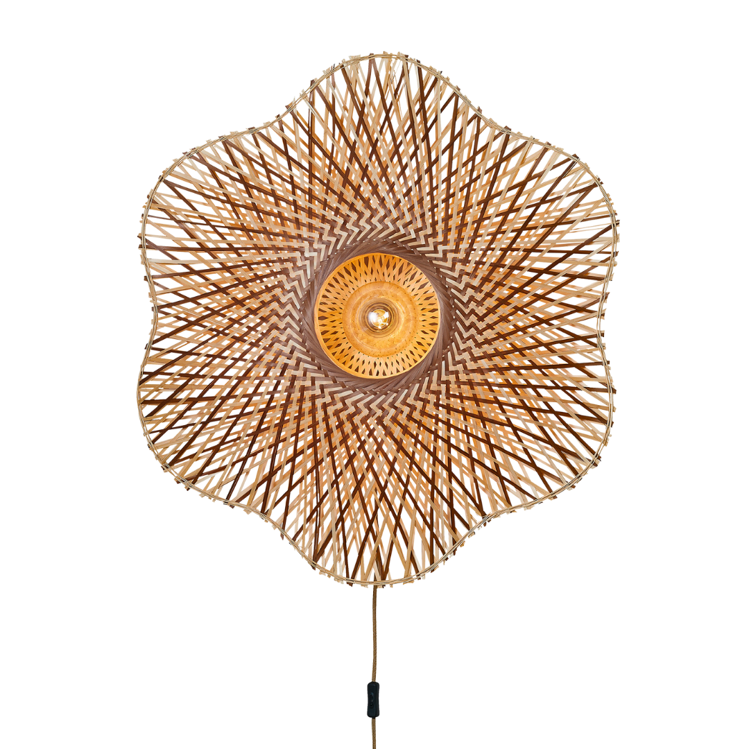 Ein Bild aus dem Taiga Store von taiga.green. Die Wandlampe Madura Bambus (ø87x20cm L) ist eine dekorative Wandleuchte mit einem blumenförmigen, geflochtenen Bambusschirm und einer leuchtenden Glühbirne in der Mitte, von vorne gesehen. Jetzt bestellen im Eco Shop von www.taiga.green. Hier nachhaltig einkaufen mit dem Taiga Eco Rating