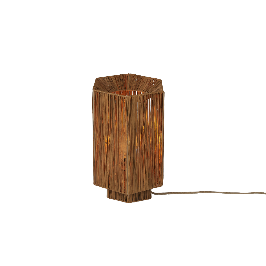 Ein Bild aus dem Taiga Store von taiga.green. Sechseckige Tischleuchte mit braunem Holzsockel und -rahmen, mit dünnen vertikalen Holzlatten, die die Glühbirne umgeben und ein warmes, diffuses Licht erzeugen. Vom Sockel geht ein Stromkabel ab. Jetzt bestellen im Eco Shop von www.taiga.green. Hier nachhaltig einkaufen mit dem Taiga Eco Rating