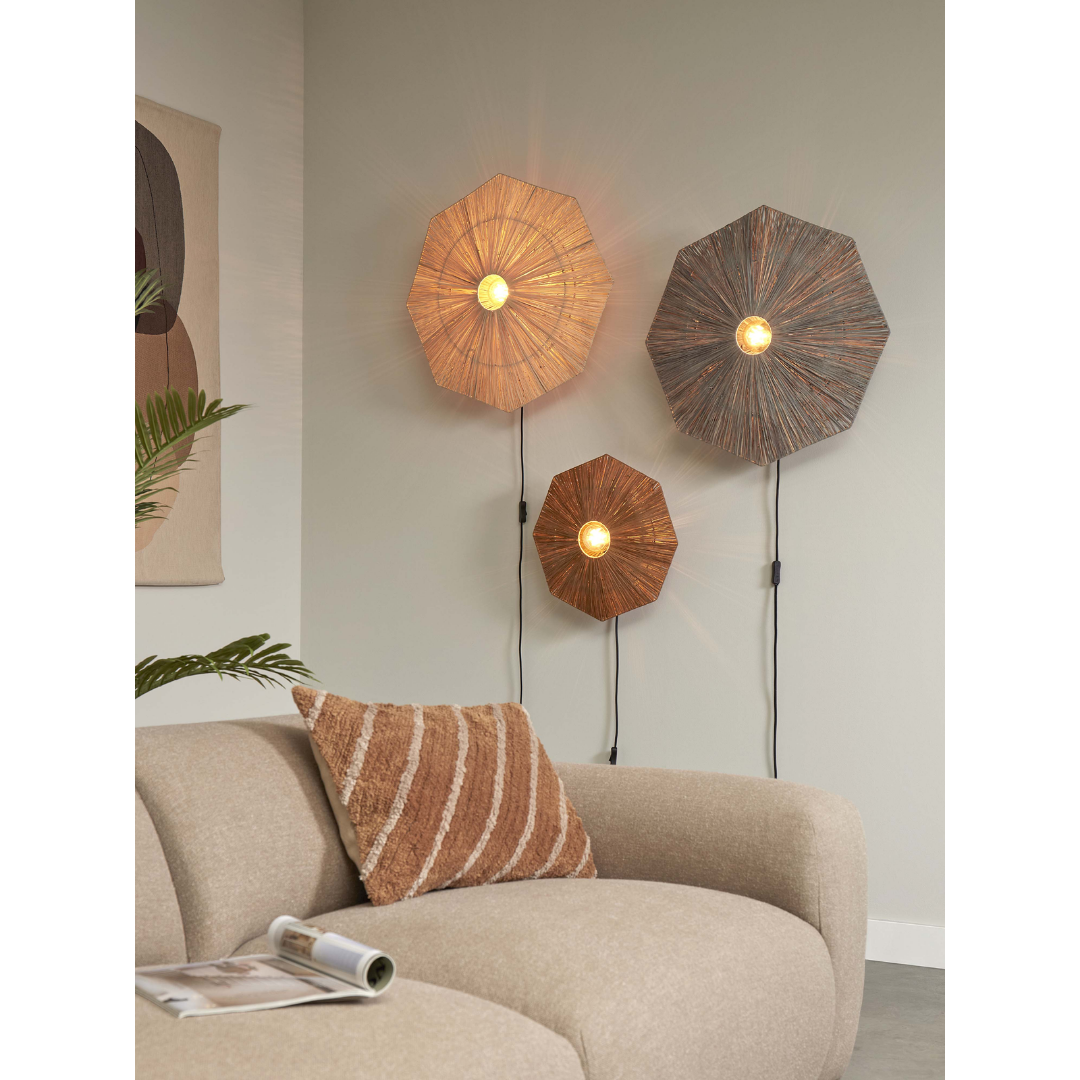 Ein Bild aus dem Taiga Store von taiga.green. Ein gemütliches Wohnzimmer mit einem beigen, geschwungenen Sofa, einem braunen, strukturierten Kissen und einer offenen Zeitschrift. An der Wand über dem Sofa sind drei Wandlampen in verschiedenen Größen angebracht, die warmes Licht verbreiten. Jetzt bestellen im Eco Shop von www.taiga.green. Hier nachhaltig einkaufen mit dem Taiga Eco Rating