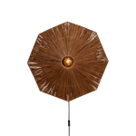 Ein Bild aus dem Taiga Store von taiga.green. Eine Stehlampe mit einem großen, achteckigen, geflochtenen Rattanschirm, der von einer zentralen, freiliegenden Glühbirne ausstrahlt, montiert auf einem schlanken schwarzen Ständer. Jetzt bestellen bei www.taiga.green.