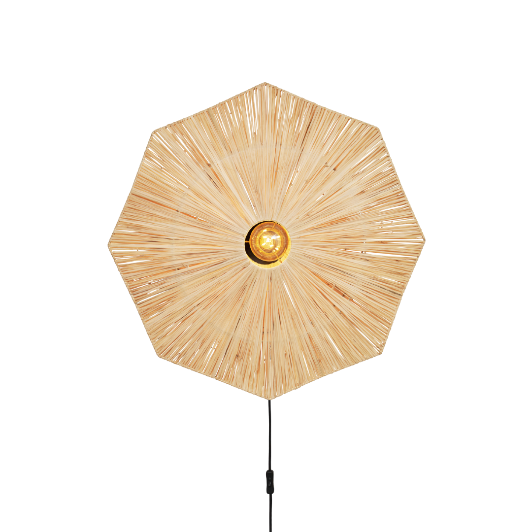 Ein Bild aus dem Taiga Store von taiga.green. Eine Stehlampe mit einem großen, sechseckigen Schirm aus geflochtenem Rattan, der von einer gelben Glühbirne in der Mitte ausstrahlt, montiert auf einer schlanken schwarzen Stange, vor einem schlichten weißen Hintergrund. Jetzt bestellen im Eco Shop von www.taiga.green. Hier nachhaltig einkaufen mit dem Taiga Eco Rating