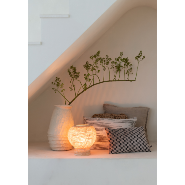 Ein Bild aus dem Taiga Store von taiga.green. In einer gemütlichen Ecke unter der Treppe sorgen neutrale Kissen, ein gemustertes Kissen, eine strukturierte Vase mit Grünzeug und die Tischlampe Barbados Bambus/Globe ø25xh.27cm für ein warmes Licht und eine ruhige, einladende Atmosphäre. Jetzt bestellen im Eco Shop von www.taiga.green. Hier nachhaltig einkaufen mit dem Taiga Eco Rating