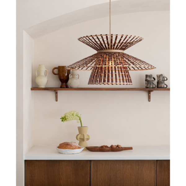Ein Bild aus dem Taiga Store von taiga.green. Eine moderne Küche mit einer weißen Arbeitsplatte, Holzschränken, einem Brotlaib und einer Vase auf der Arbeitsplatte, einer hölzernen Pendelleuchte und einem Regal mit Keramikvasen und -bechern vor einer hellen Wand. Jetzt bestellen im Eco Shop von www.taiga.green. Hier nachhaltig einkaufen mit dem Taiga Eco Rating