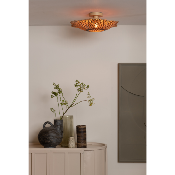 Ein Bild aus dem Taiga Store von taiga.green. Die Deckenlampe Madura Bambus/Schirm ø44x12cm S wirft ein warmes Licht über einen beigen Konsolentisch mit Keramikvasen - eine davon mit grünen Zweigen - vor einer cremefarbenen Wand mit moderner abstrakter Kunst. Jetzt bestellen im Eco Shop von www.taiga.green. Hier nachhaltig einkaufen mit dem Taiga Eco Rating