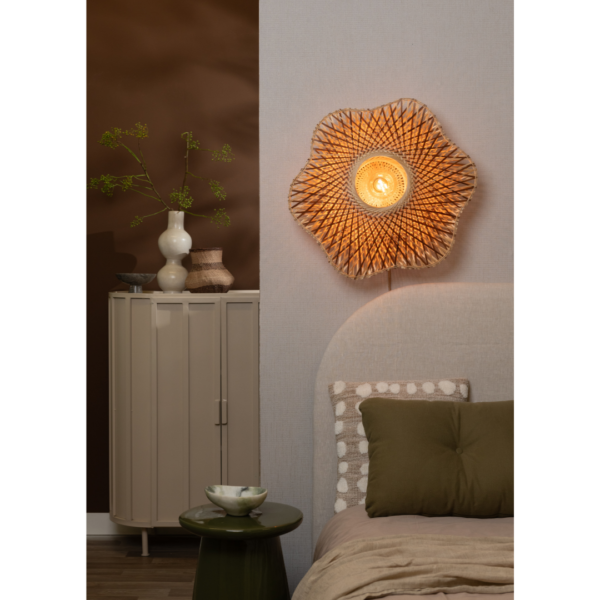 Ein Bild aus dem Taiga Store von taiga.green. Ein gemütliches Schlafzimmer mit der Wandlampe Madura Bambus ø60x15cm M, einem beigen Kopfteil, olivgrünen Kissen und Bettzeug, einem grünen Beistelltisch mit Dekor und einem beigen Schrank mit Vasen vor braunen und beigen Wänden. Jetzt bestellen im Eco Shop von www.taiga.green. Hier nachhaltig einkaufen mit dem Taiga Eco Rating