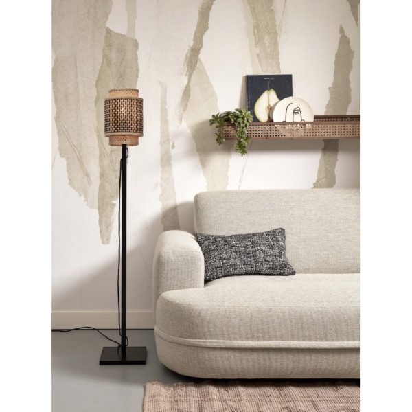 Ein Bild aus dem Taiga Store von taiga.green. Ein modernes Wohnzimmer mit einem hellgrauen Sofa, einem strukturierten schwarz-weißen Kissen, einer schwarzen Stehlampe mit gewebtem Schirm, einem beigen Teppich und einem Wandregal mit Büchern und Dekorationsgegenständen vor einer gemusterten Wand. Jetzt bestellen im Eco Shop von www.taiga.green. Hier nachhaltig einkaufen mit dem Taiga Eco Rating