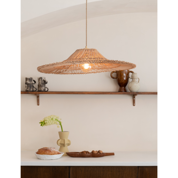 Ein Bild aus dem Taiga Store von taiga.green. Eine Pendelleuchte aus geflochtenem Rattan hängt über einer weißen Arbeitsplatte mit einem Laib Brot, Nüssen und einer Vase mit einer einzelnen Blume, während im Hintergrund rustikale Keramik auf einem Holzregal steht. Jetzt bestellen im Eco Shop von www.taiga.green. Hier nachhaltig einkaufen mit dem Taiga Eco Rating