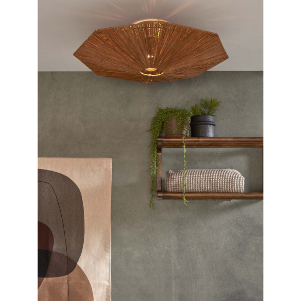 Ein Bild aus dem Taiga Store von taiga.green. Ein moderner Raum mit einer geflochtenen Deckenleuchte, einer grünen Wand, einem Holzregal mit Topfpflanzen und Handtüchern und einem abstrakten Wandbehang in neutralen Tönen. Jetzt bestellen im Eco Shop von www.taiga.green. Hier nachhaltig einkaufen mit dem Taiga Eco Rating