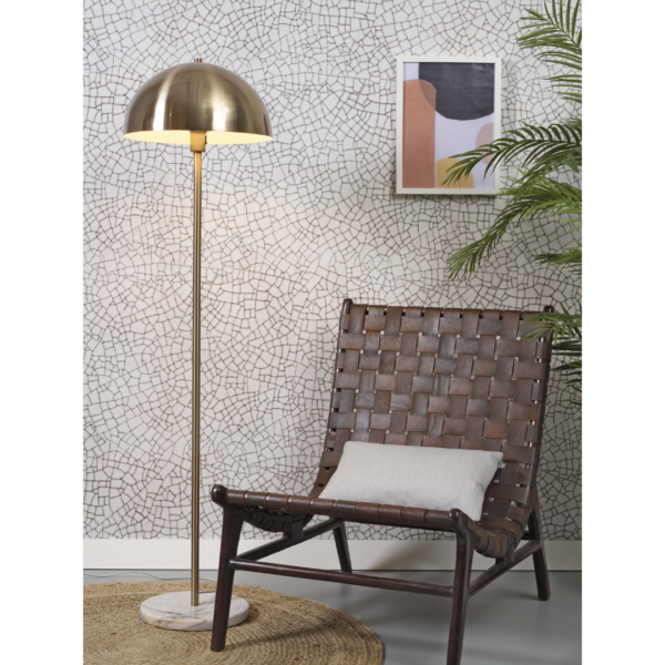 Ein Bild aus dem Taiga Store von taiga.green. Eine gemütliche Ecke mit einem geflochtenen braunen Stuhl und einem hellen Kissen, daneben eine goldene Stehlampe auf einem runden Teppich. Geometrische Kunst hängt an einer Wand mit Mosaikmustern neben einer grünen Topfpflanze. Jetzt bestellen im Eco Shop von www.taiga.green. Hier nachhaltig einkaufen mit dem Taiga Eco Rating